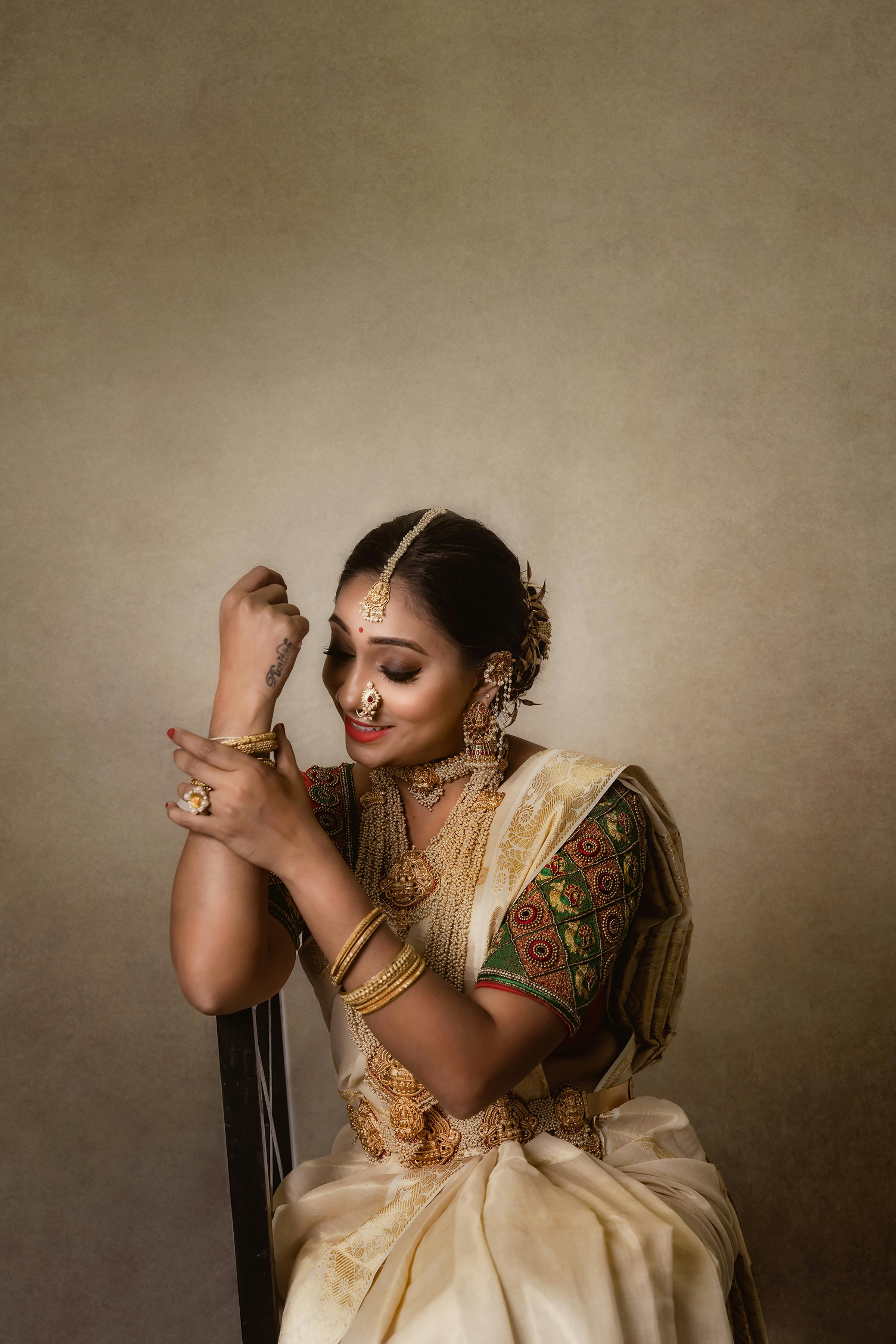 Bride Sitting in Traditional Clothing Fixing her Hair · Free Stock Photo