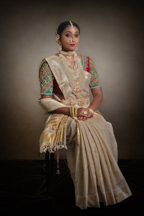 Free A Woman in Brown Sari Dress Sitting on a Chair Stock Photo