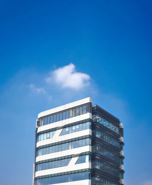 Free A contemporary glass skyscraper with sleek design under a vibrant blue sky, capturing urban architecture. Stock Photo