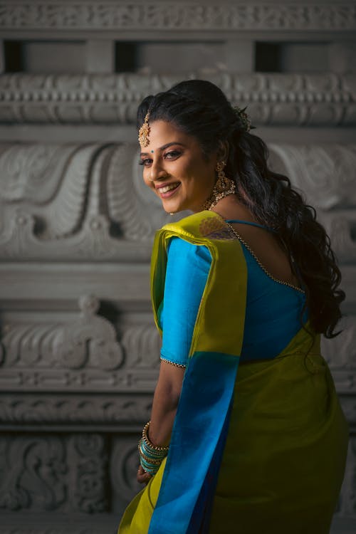 Woman in Blue and Green Dress Looking Over Her Shoulder