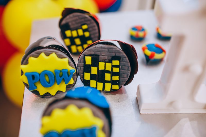 Colorful superhero-themed cupcakes and party treats