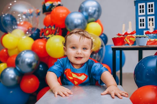 A Toddler Wearing a Superman Shirt