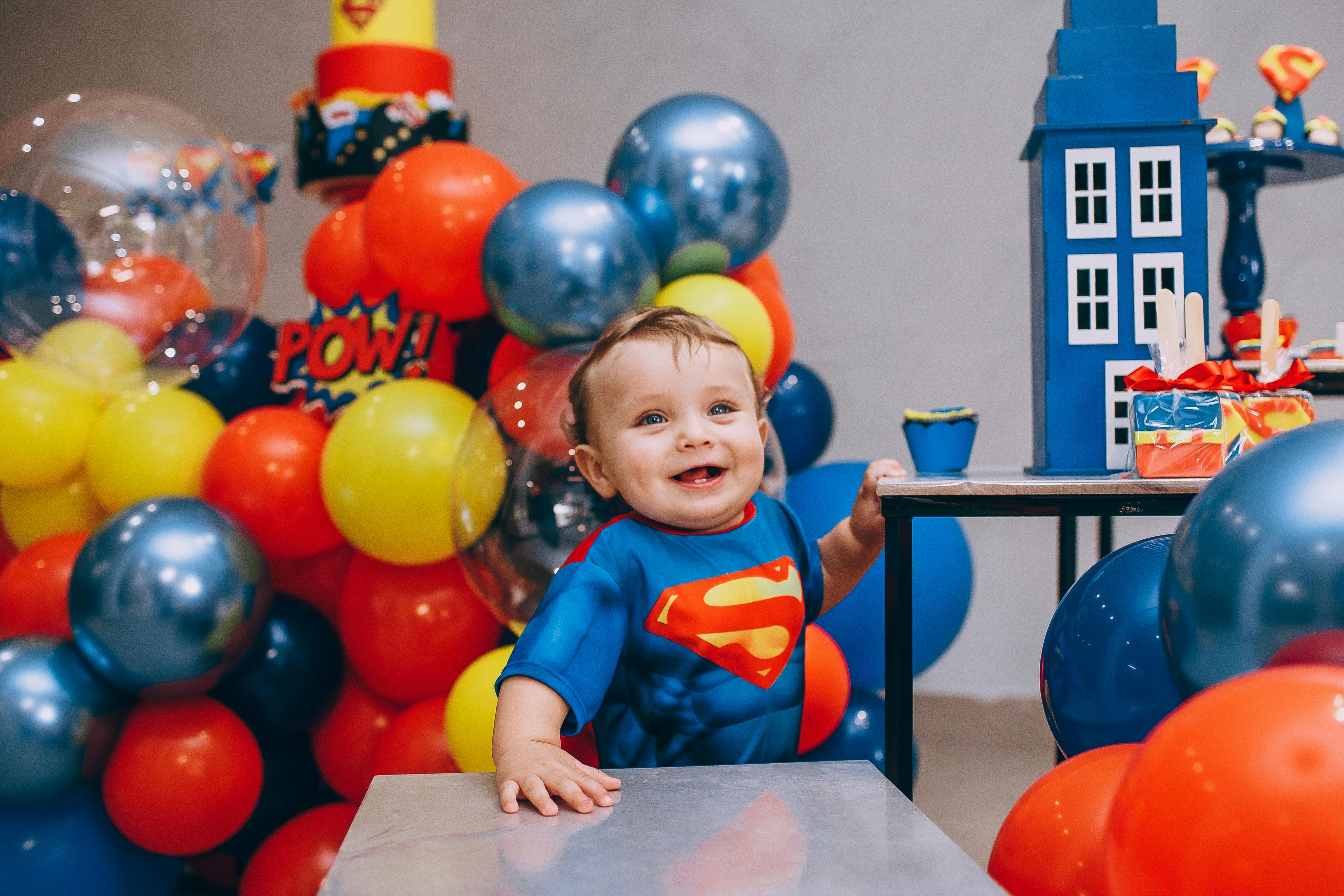 cute kid dressed up in superman costume on his 1st birthday