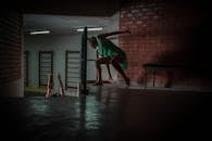 在玻利维亚圣克鲁斯，一名妇女在室内利用戏剧性的灯光，在砖墙上展现出舞蹈的姿态