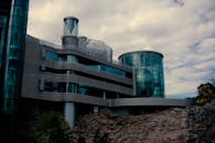 一座现代的未来主义建筑，在多云的天空下展现出玻璃立面和独特的造型