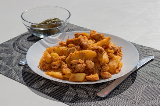 A delicious plate of chicken and potatoes served with pickles on an outdoor table in Szántód.