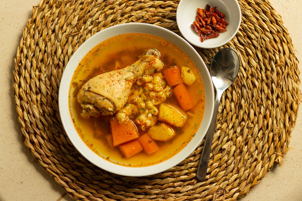 Chicken soup with carrots and potatoes served in a bowl