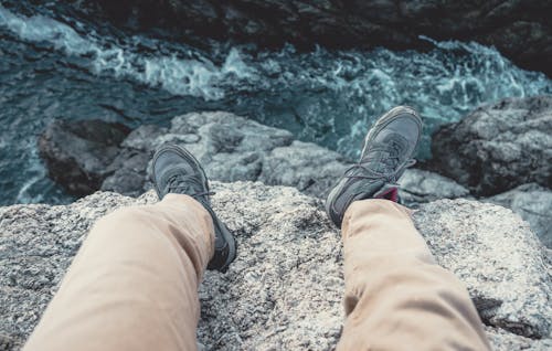 Photo of Man Sitting on the Cliff