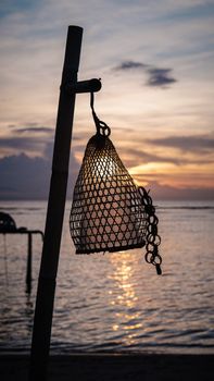 A calming sunset at the beach with a net lamp silhouette in West Nusa Tenggara, Indonesia.