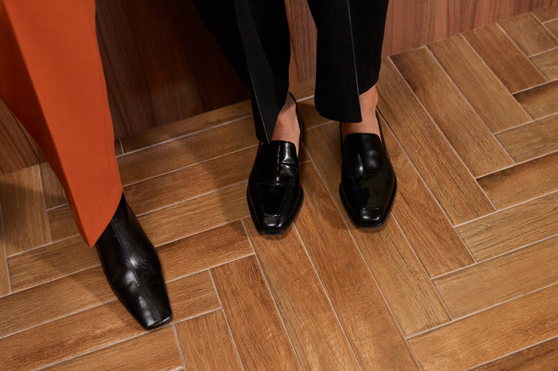 Free Elegant black shoes and orange pants on a stylish wooden herringbone floor. Stock Photo