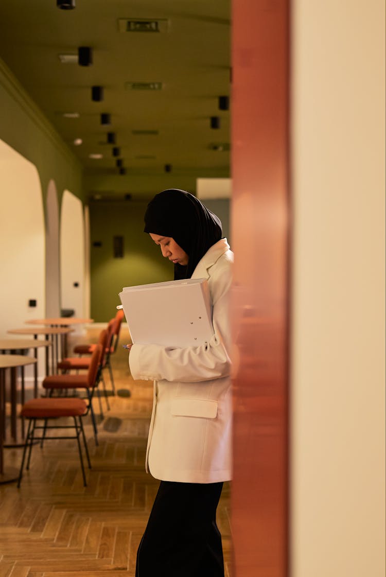 Hijabi Woman Leaning Against Office Wall