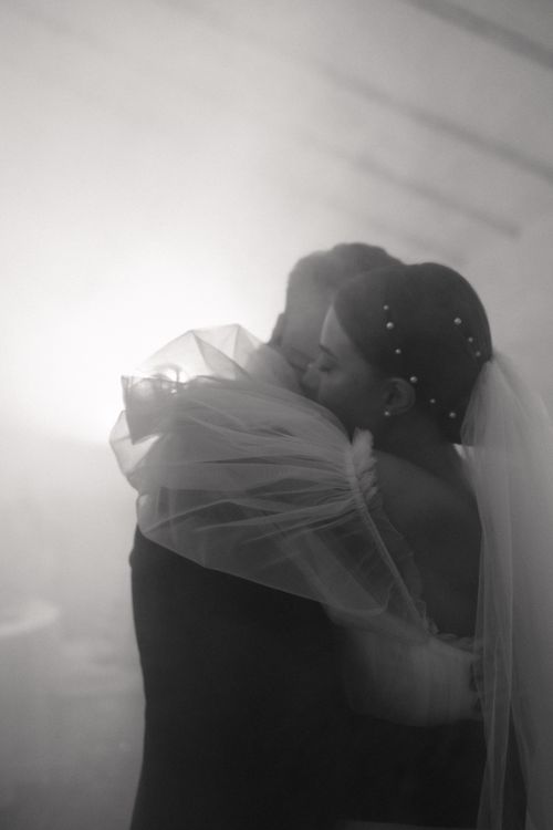 Free Romantic black and white photo of a couple embracing at their wedding, capturing genuine love. Stock Photo