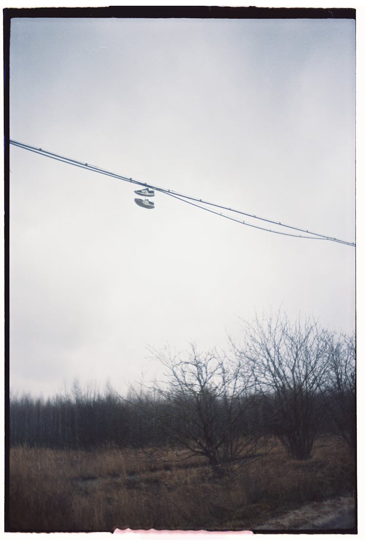 Pair Of Sneakers Hanging On Wires