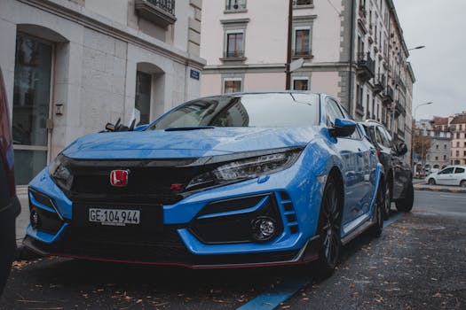 A stylish blue sports car parked on a city street with surrounding buildings.