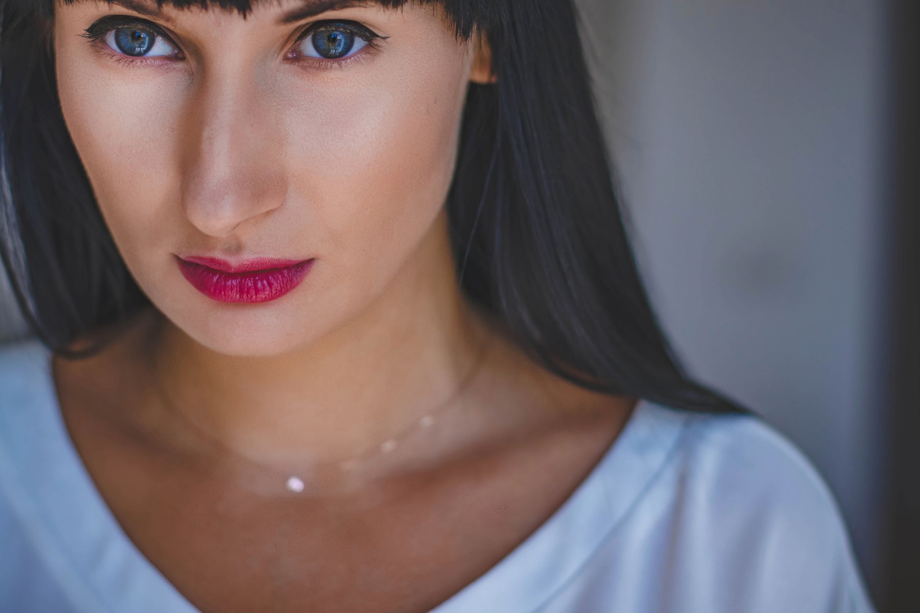 woman gently applying cool water to red irritated facial skin after a skincare reaction