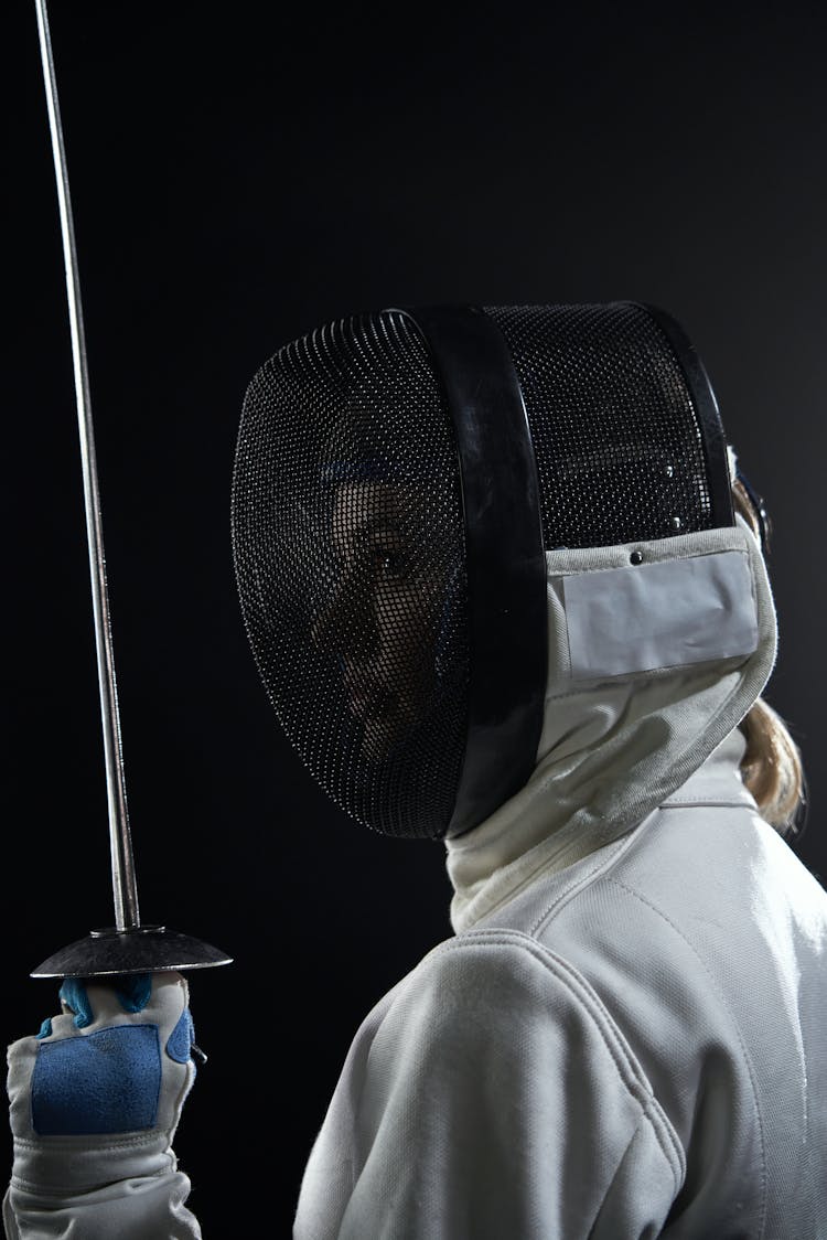 Woman In Fencing Uniform Posing While Holding A Foil Sword