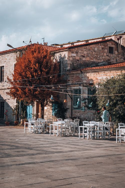 Free Picturesque outdoor cafe in Foça, İzmir, Turkey, with empty tables and autumn ambience. Stock Photo
