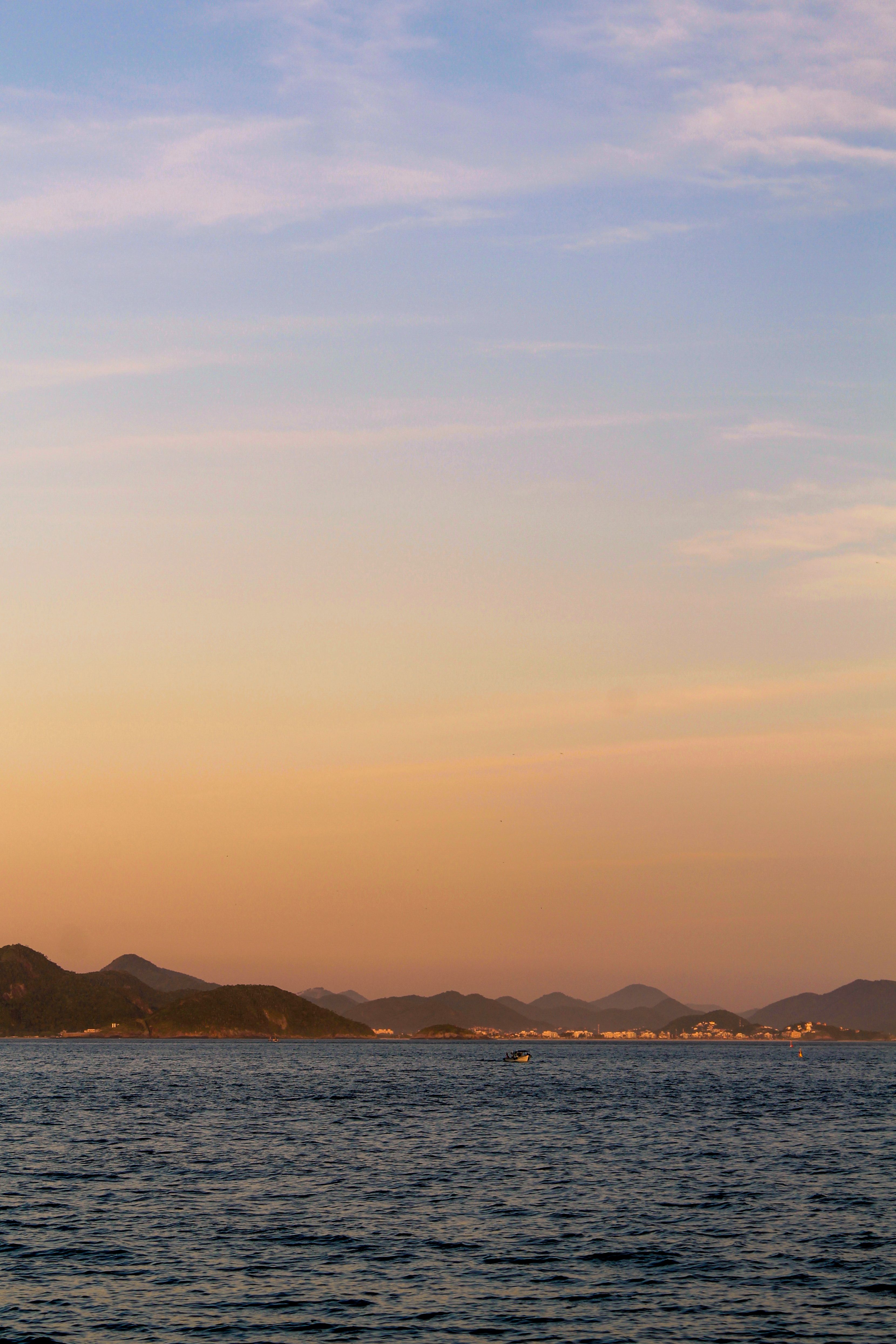Silhouette of Mountain Near Body of Water during Sunset · Free Stock Photo