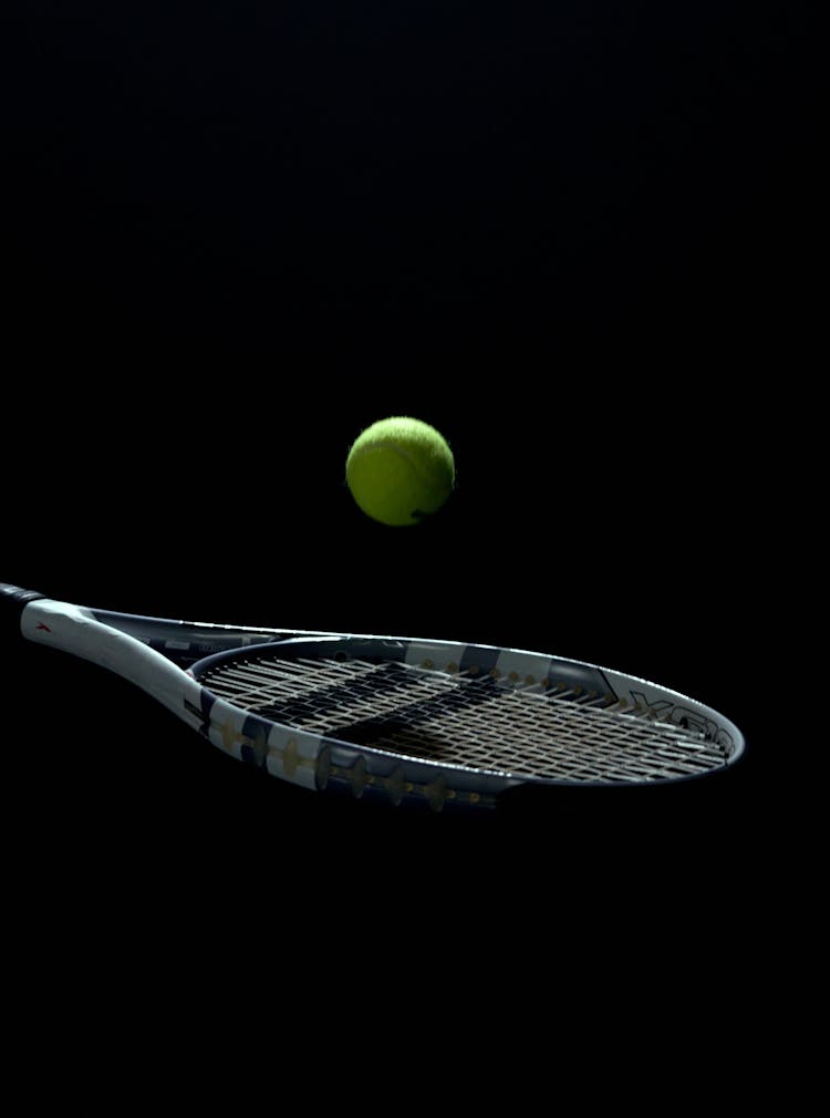 A Tennis Ball Bouncing Off A Tennis Racket