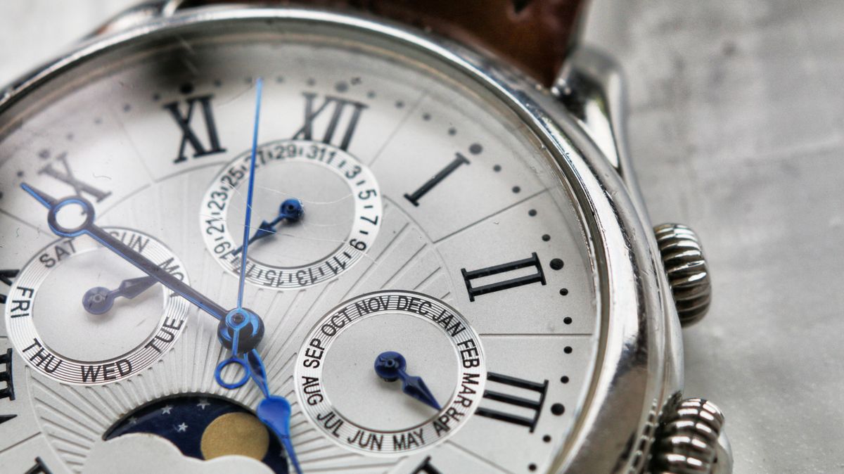 Macro view of a silver calendar dial with blued hands — photo by Mat Brown on Pexels