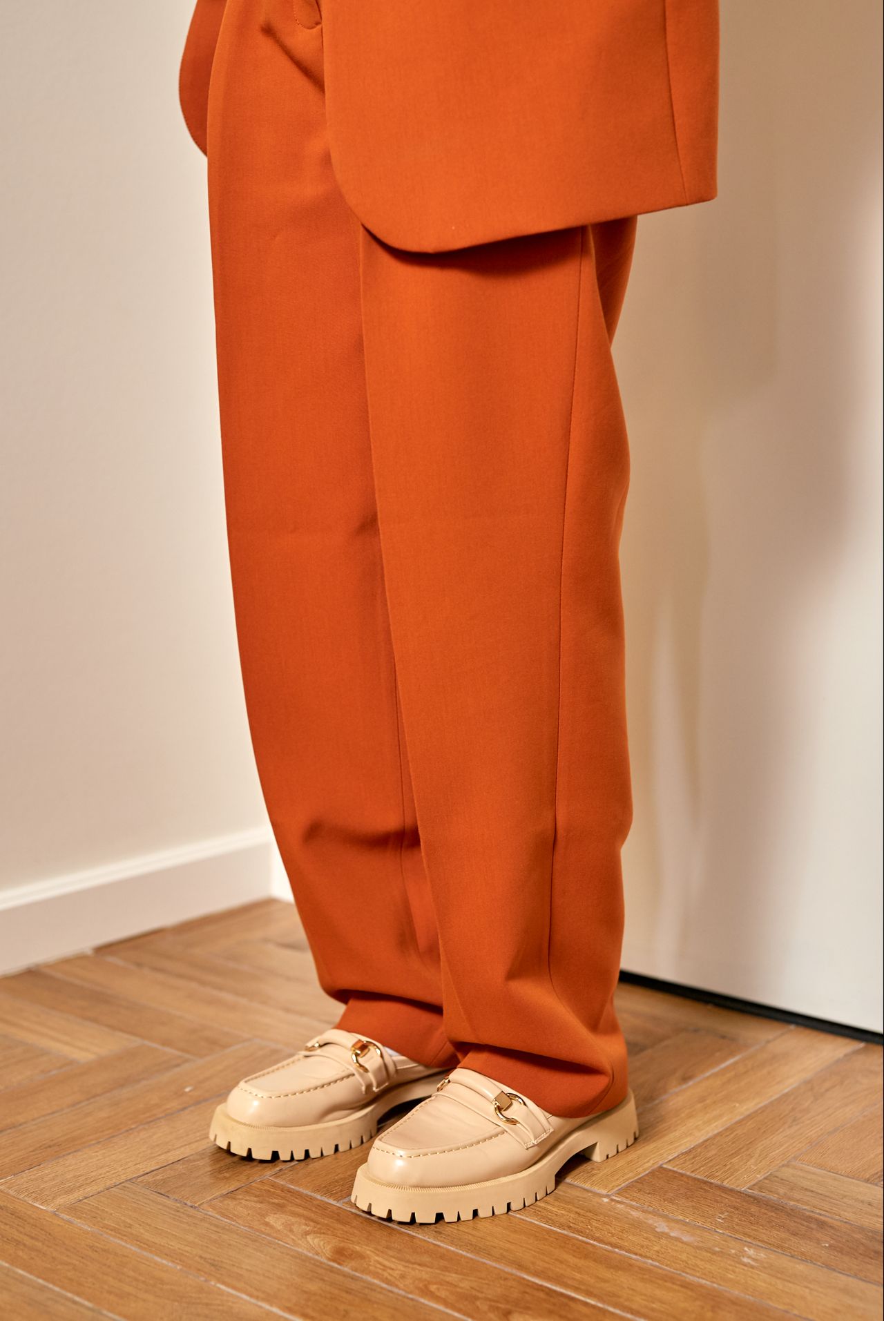 Rust-orange wide-leg trousers with chunky cream loafers