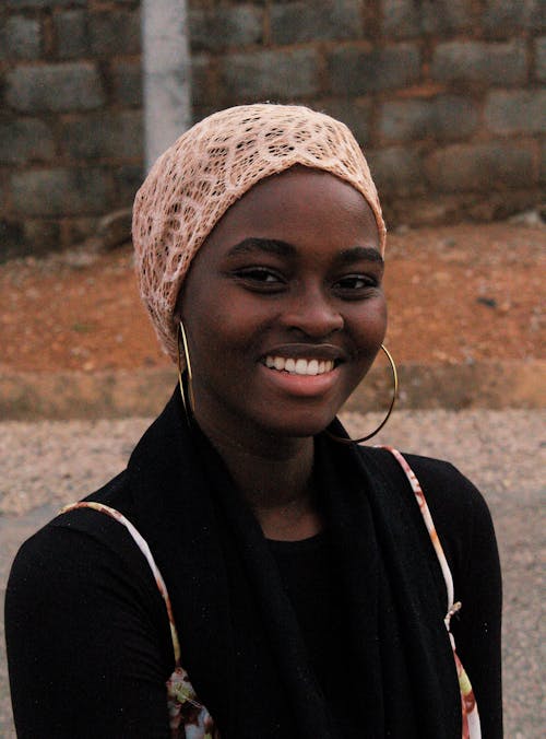 Smiling Woman Wearing a Black Top and Headscarf