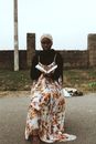 Woman in Long Dress Sitting Reading a Book