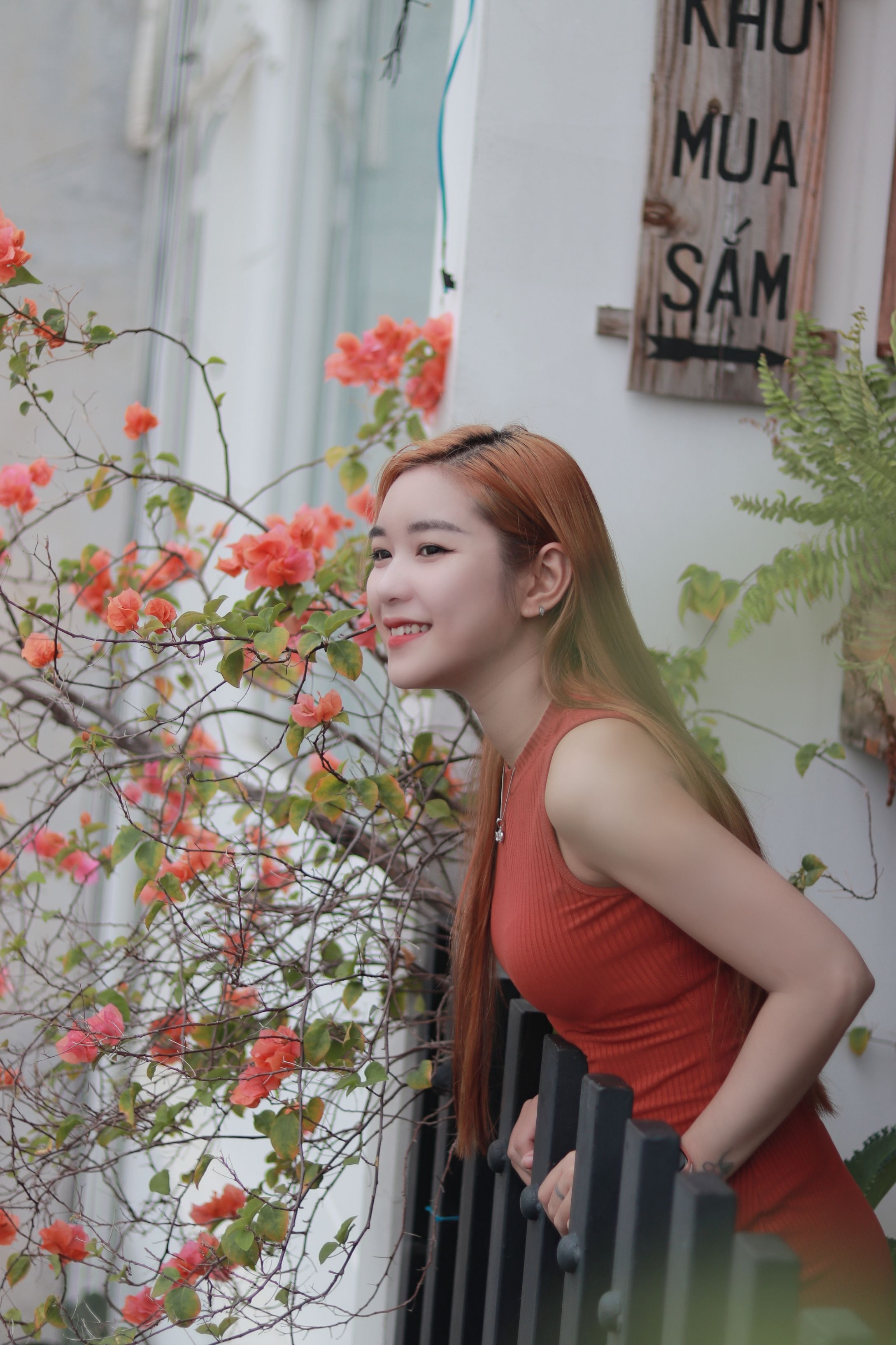 Woman in Sleeveless Top Leaning on Metal Railing · Free Stock Photo