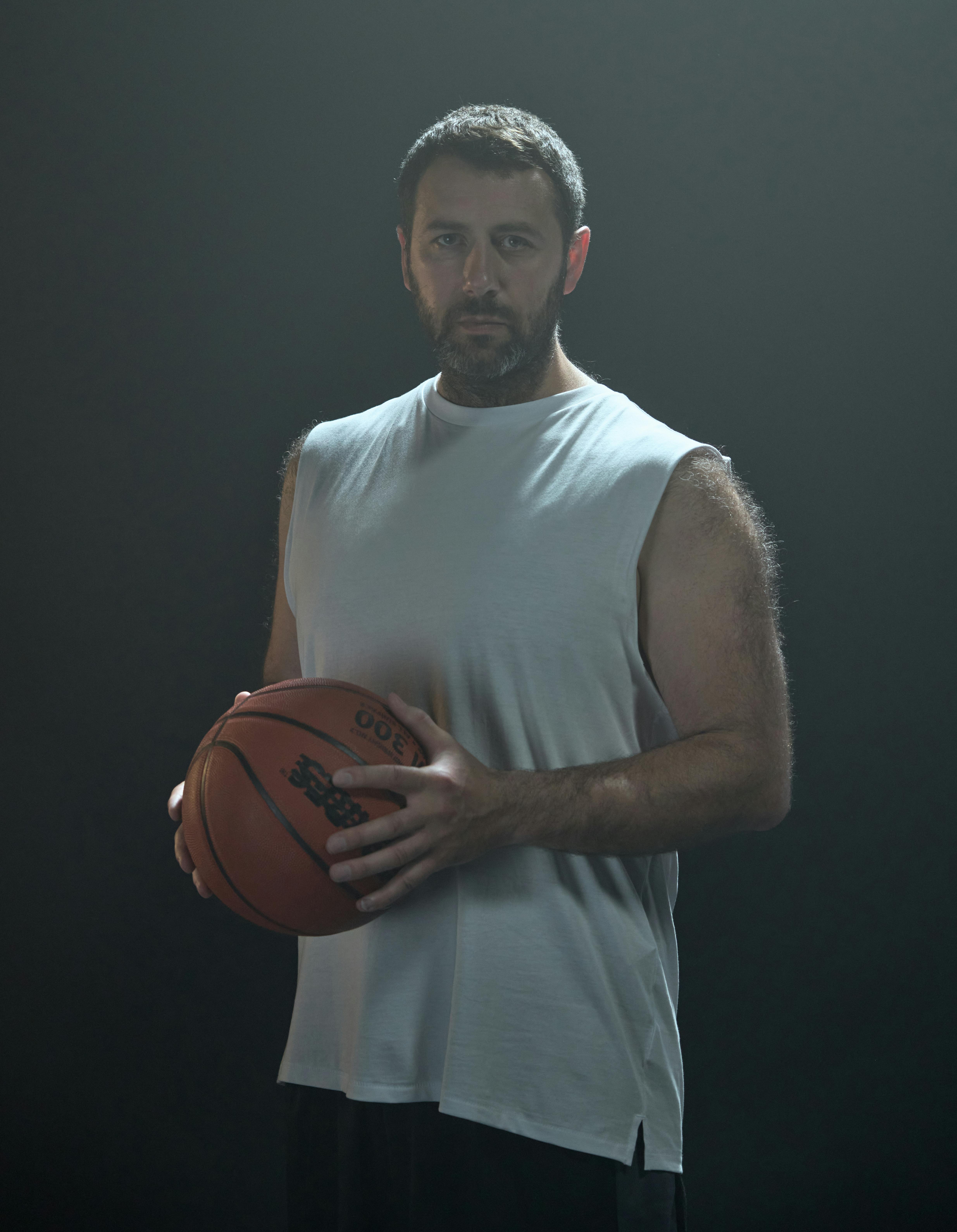 Man Posing in Basketball Tank Top on White Fabric · Free Stock Photo