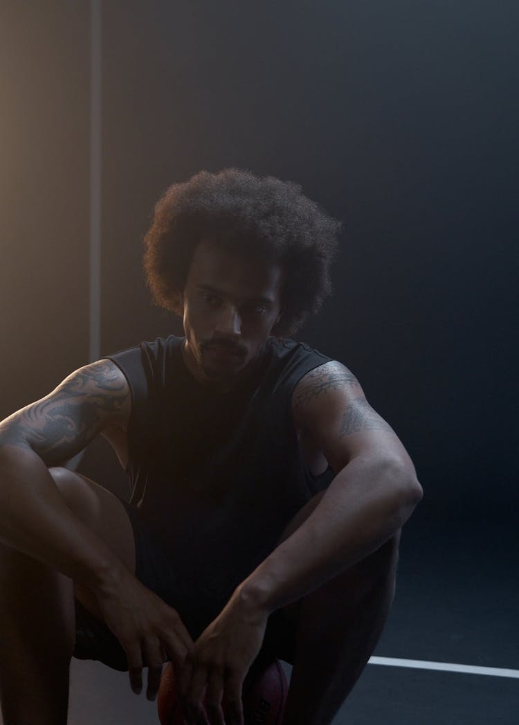 Man With Afro Hair Sitting On A Ball