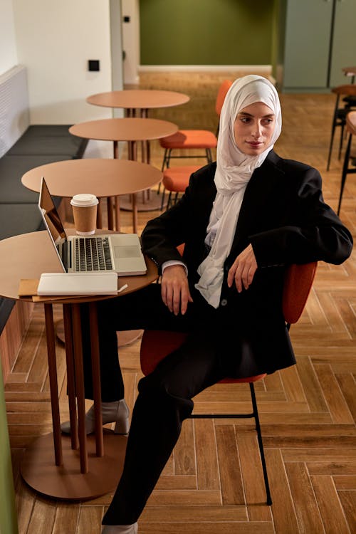 Free A Female Sitting at a Table with aLaptop on It  Stock Photo