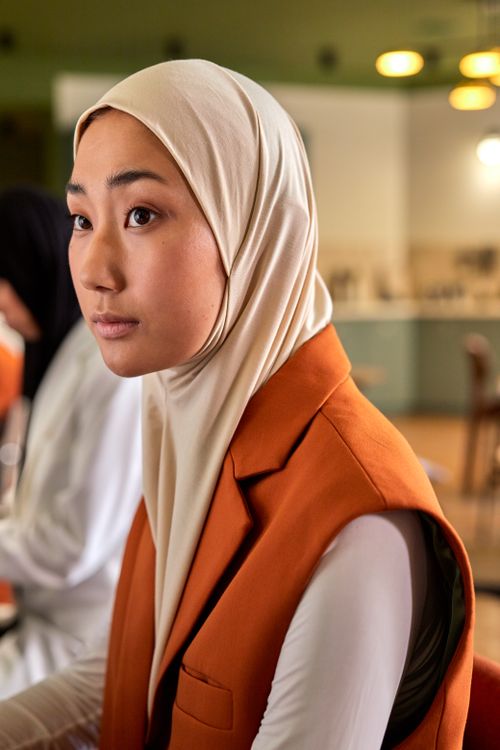 Free Young Muslim woman in a hijab working in a contemporary office setting. Stock Photo