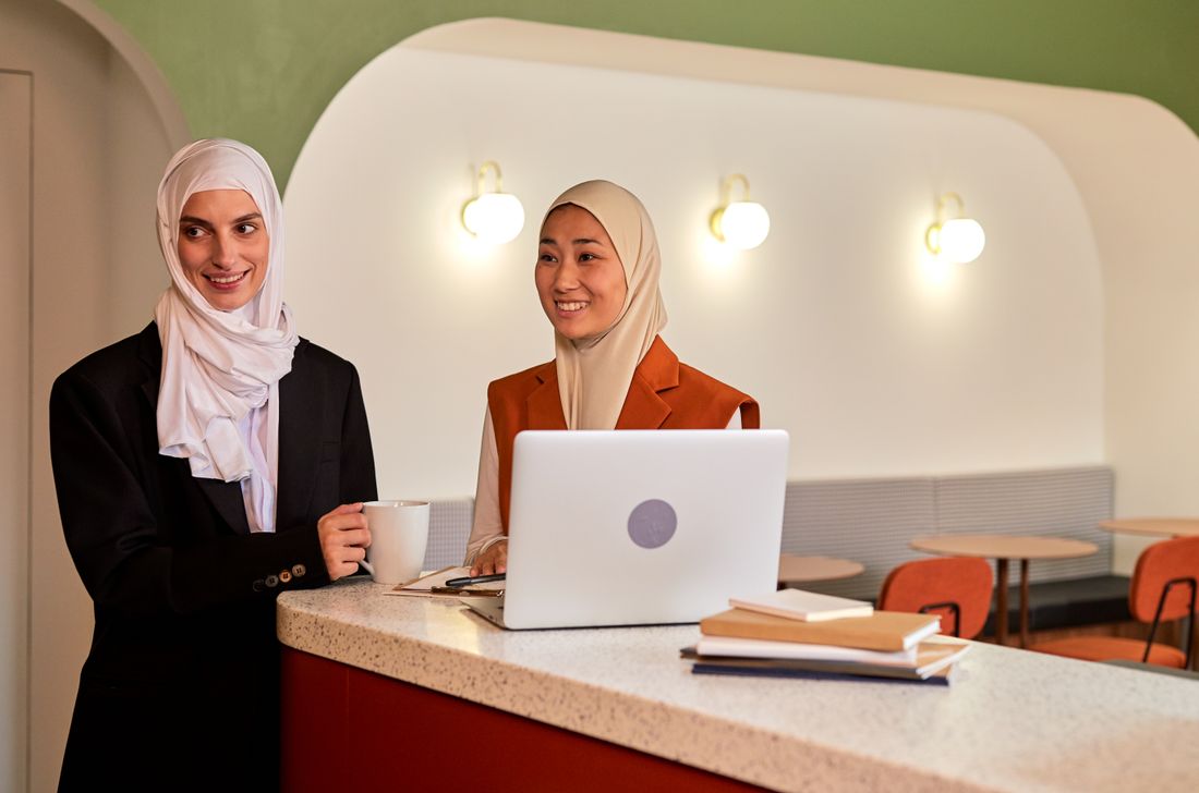 Two women in a modern office discussing work