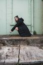 Man in Black Jacket and Black Pants Sitting on Concrete Stair
