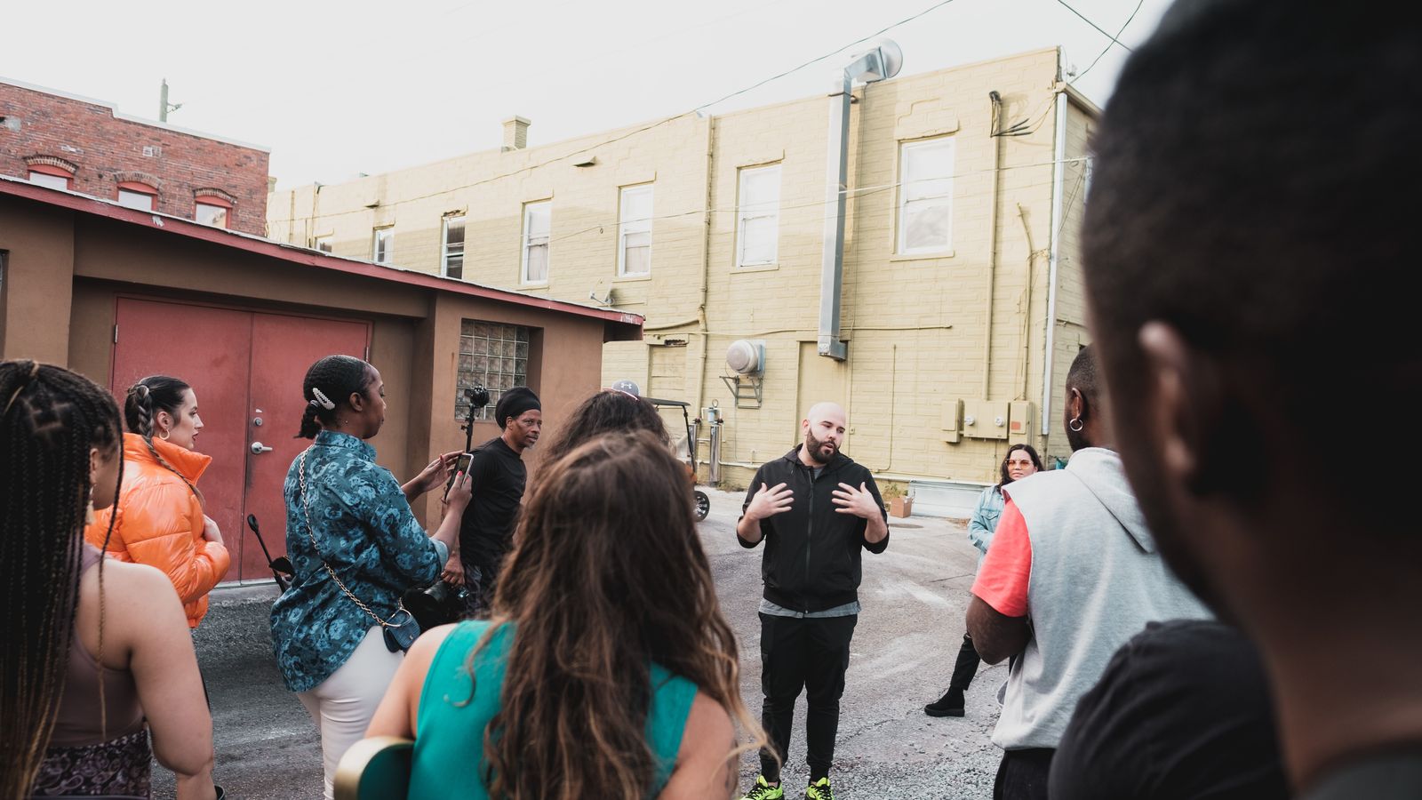A diverse group of adults engaging in a community meeting on an urban Sanford street.