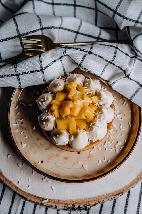 Free Delicious mango and coconut dessert elegantly presented with checkered tea towel and wooden backdrop. Stock Photo