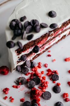 Slice of raspberry chocolate cake with chocolate chips on a plate.