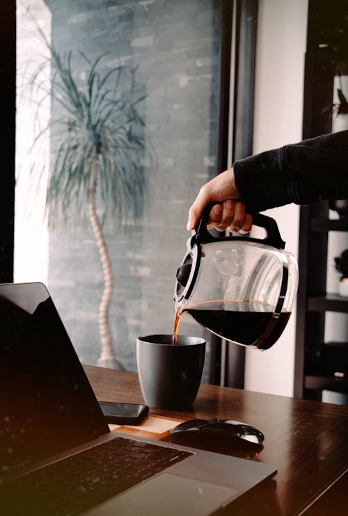 Free Person Pouring Coffee in Ceramic Mug Stock Photo