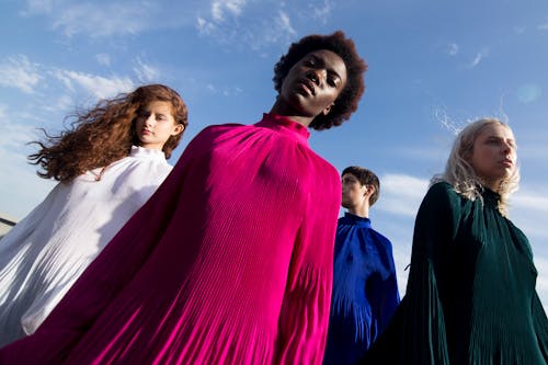 Low-angle Photography of Four Women in Assorted-color Long-sleeved Turtle-neck Dresses