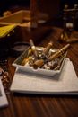Cigarette Butts on Black Round Ashtray