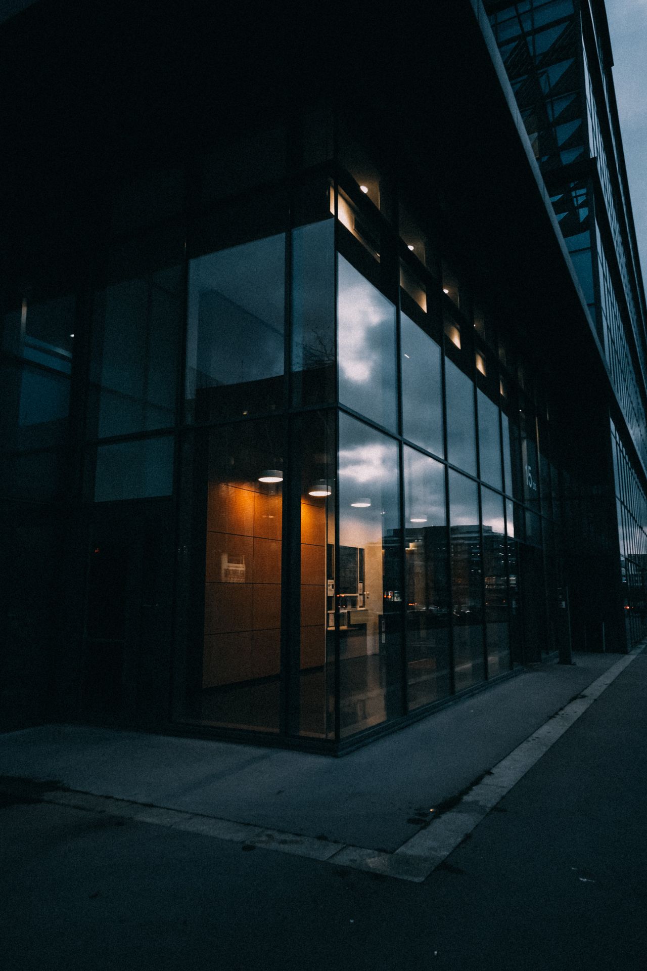 Dramatic shot of a modern glass building reflecting the evening sky at dusk