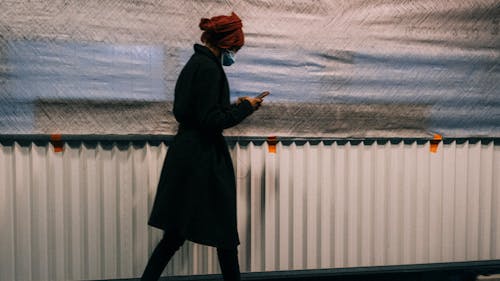 Free A Woman using a Smartphone while Walking Stock Photo