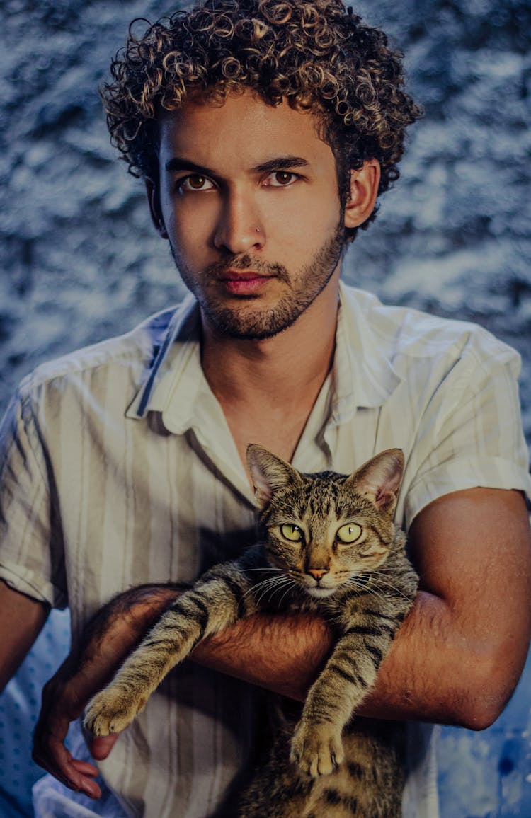 A Man Holding A Tabby Cat