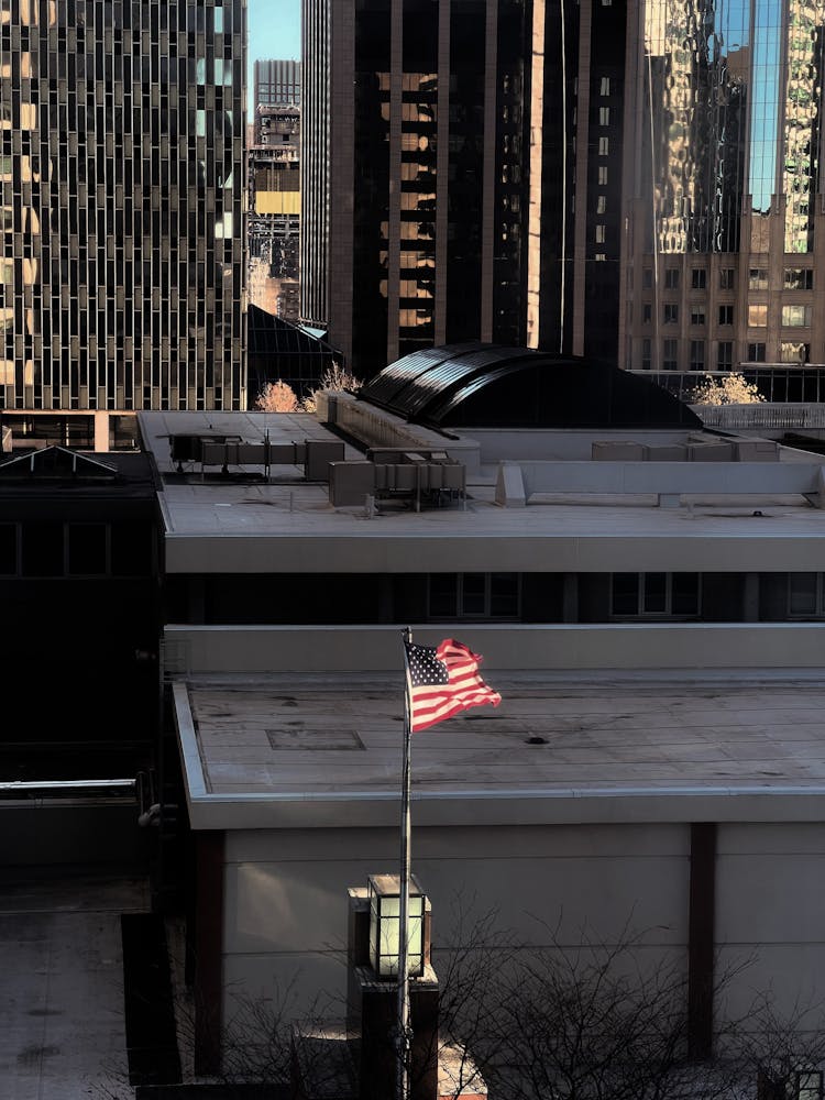 American Flag Flying Above Roof Of Building