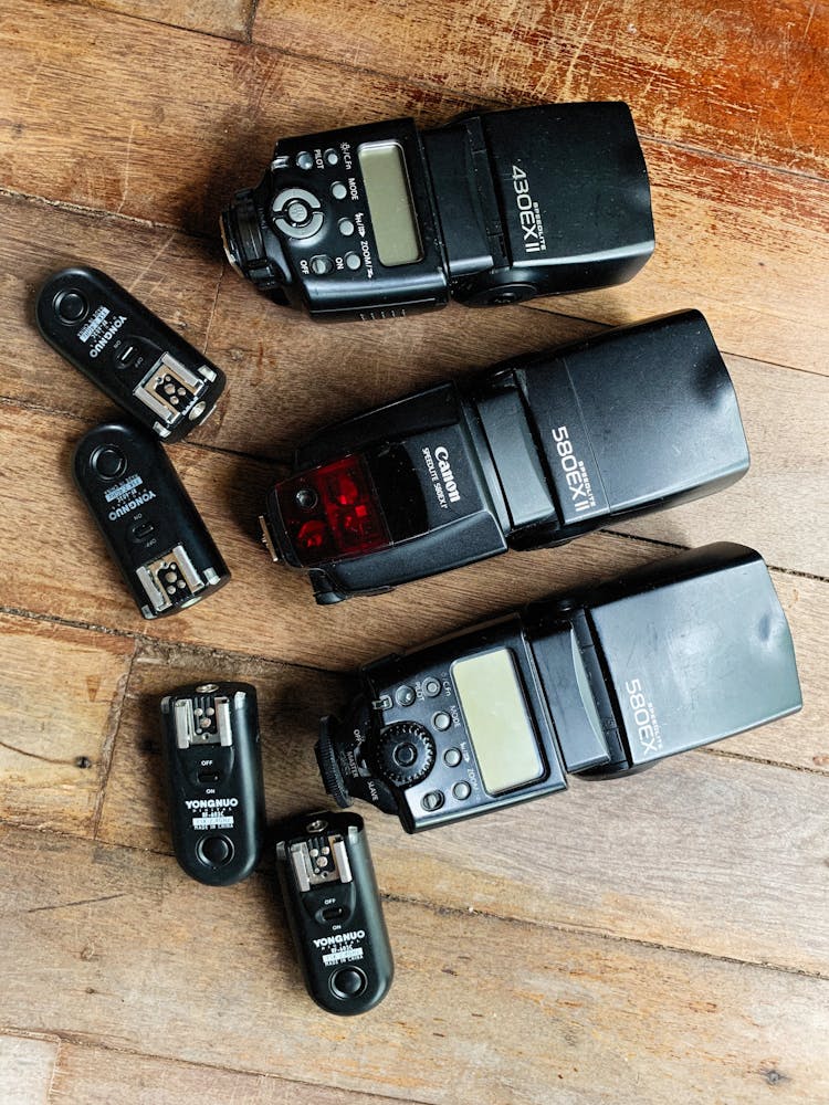 Black Camera Flashes On Wooden Surface