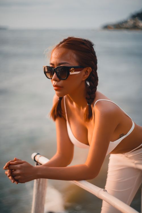 Free A woman in white attire enjoys a relaxing boat ride under the sun. Stock Photo