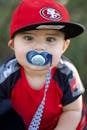 Boy in Red and Blue Crew Neck T-shirt Wearing Brown Hat