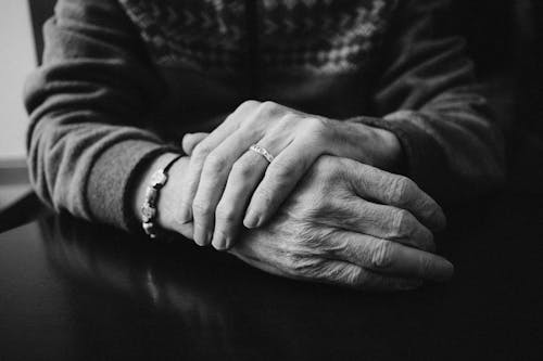 Grayscale Photo of a Person Wearing Ring