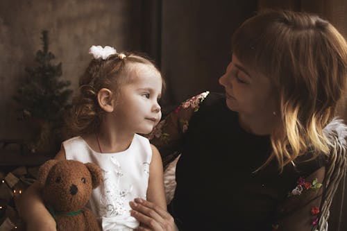 Mother Looking at Daughter with Brown Bear Toy