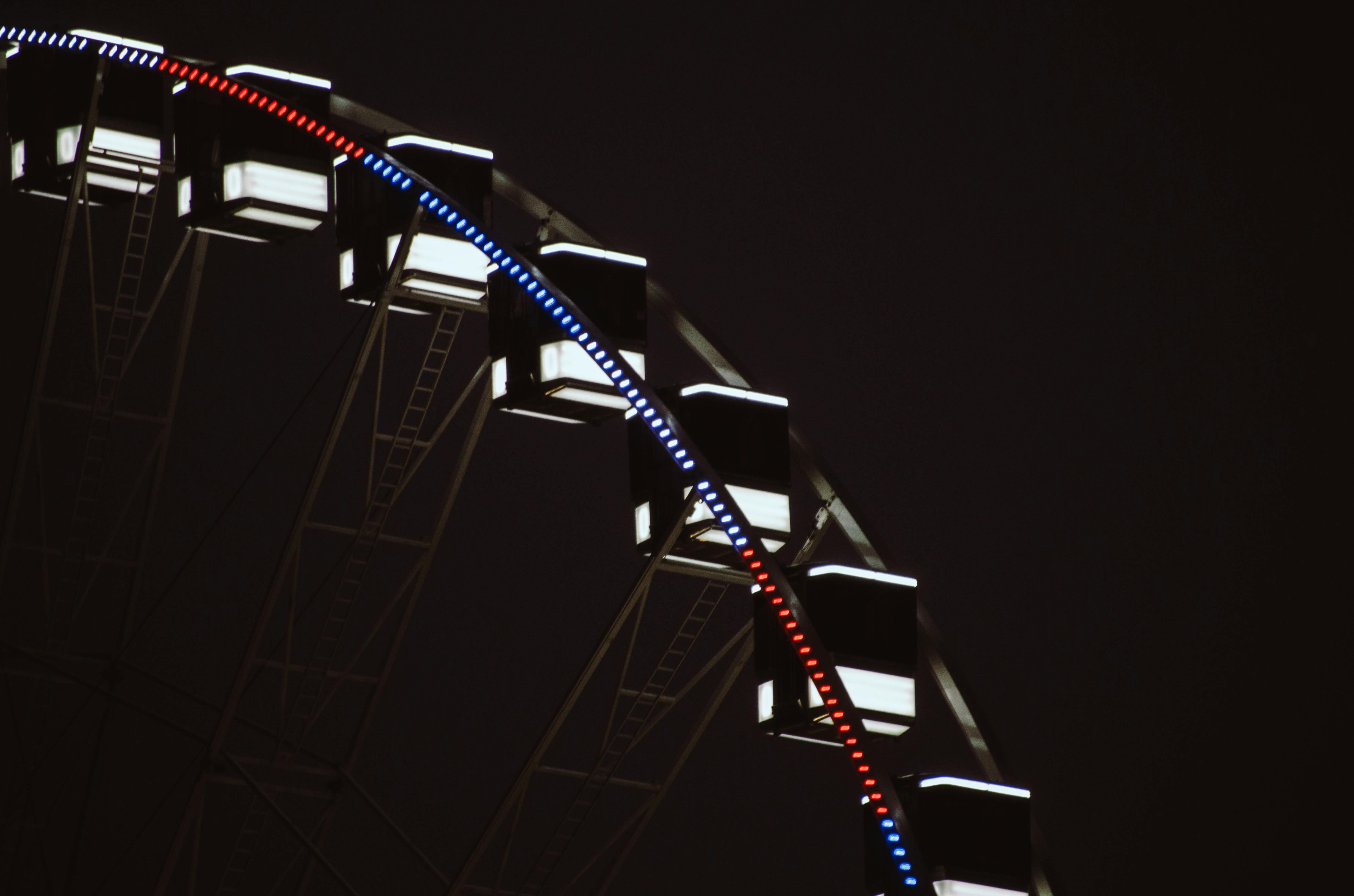 Close-up of a brightly lit Ferris wheel against the night sky in Paris, France.